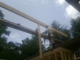 Carpenter setting a ridge beam over a new addition frame — Ice Dam Removal by Roofing Brothers in Aroma Park