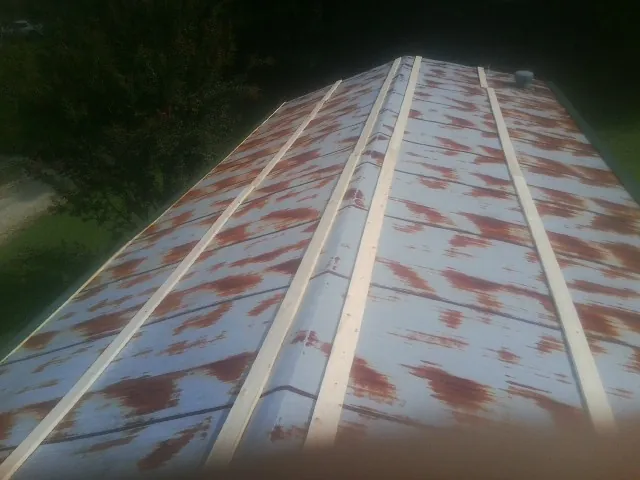 Rusted metal roof panels with new wood purlins before replacement — Storm Damage Roof Repair in Aroma Park by Roofing Brothers
