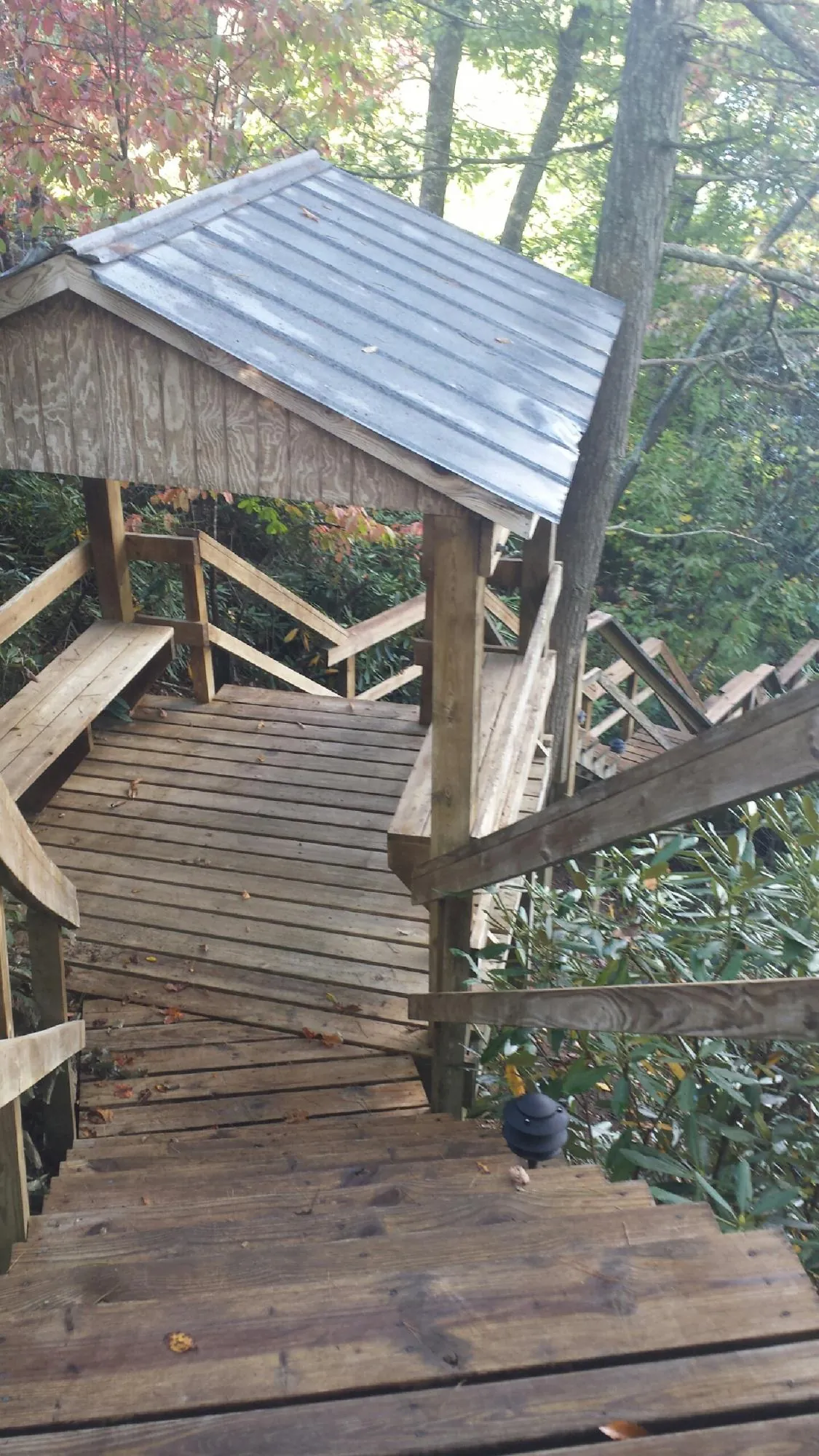 Metal roofed shelter over wooden steps on a wooded walkway — Skylight Repair & Installation work by our crew in Aroma Park