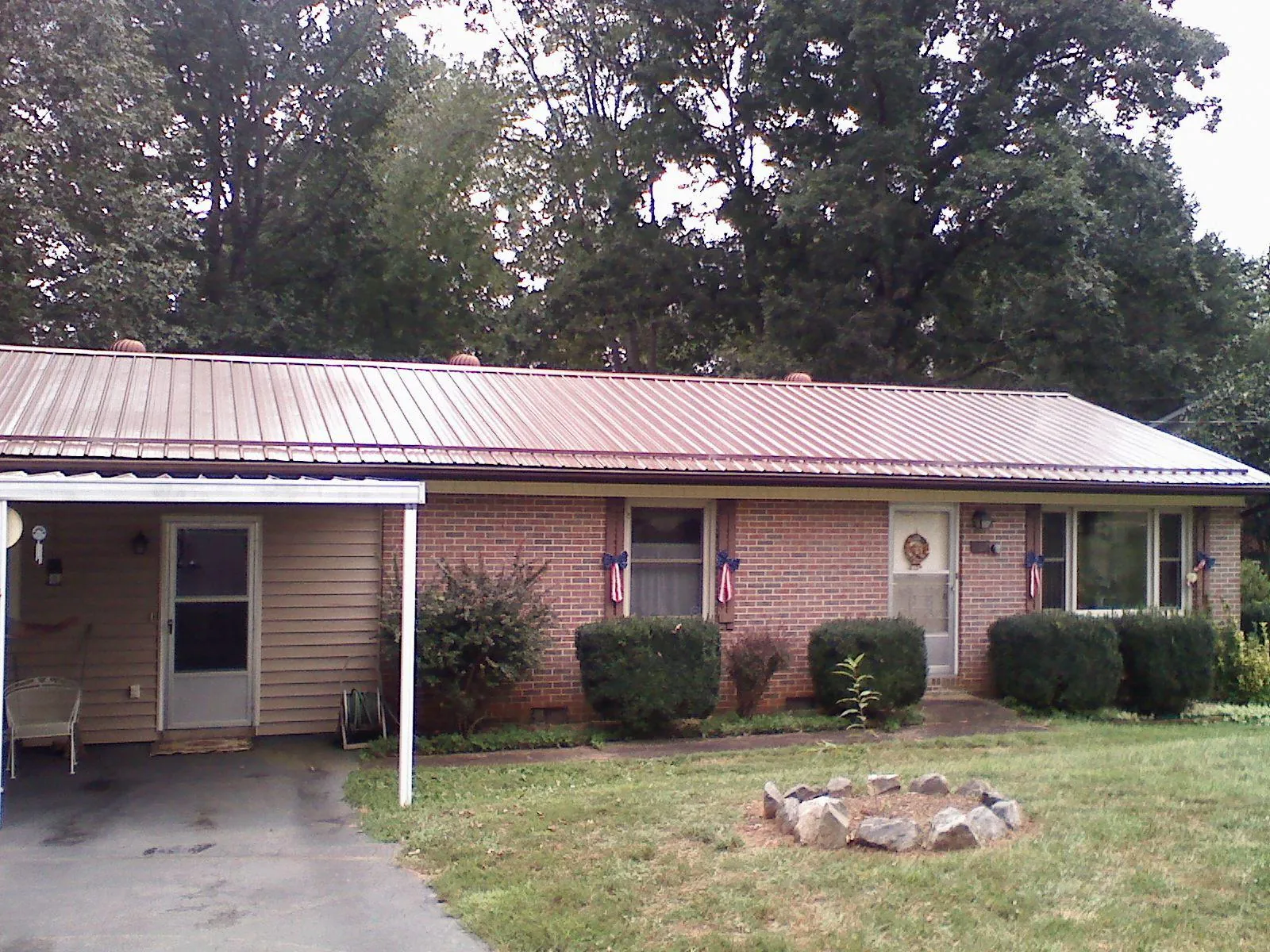 Bronze metal roof and carport on a brick ranch home — Roof Repair work by our crew in Aroma Park
