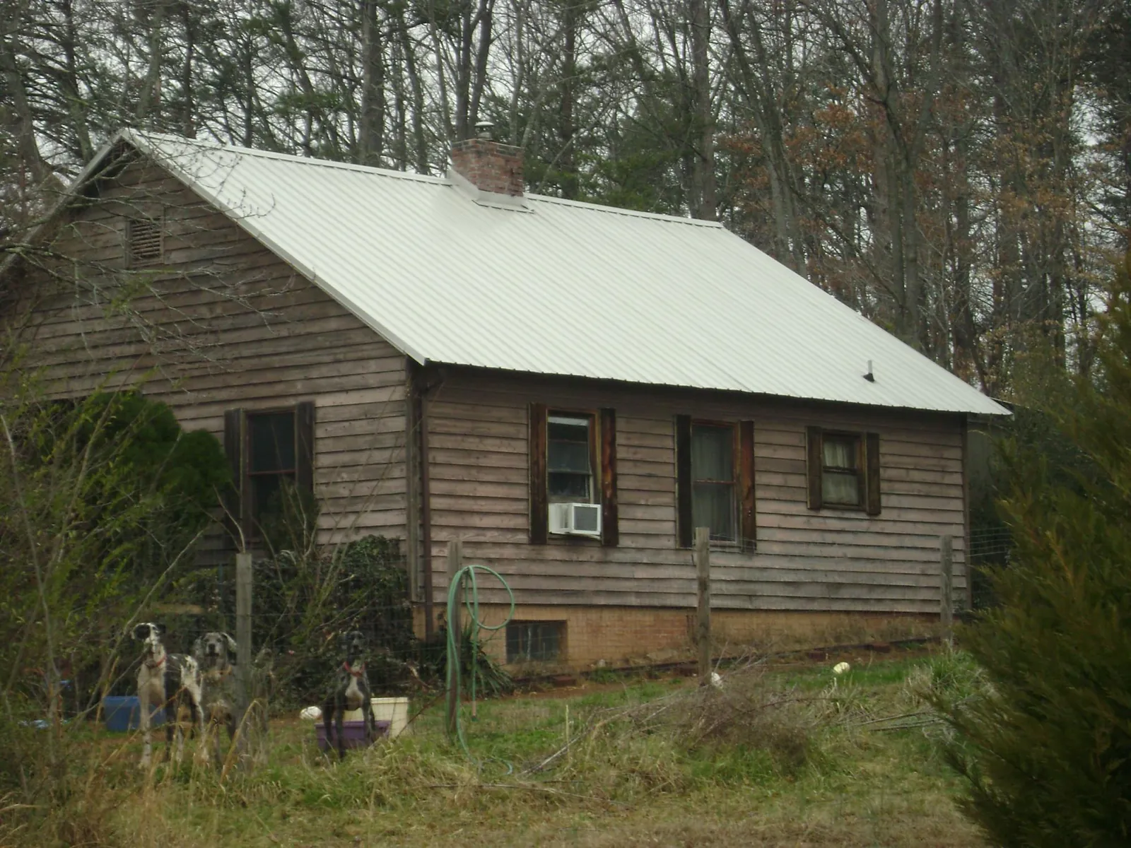 White metal roof on an old wood sided farmhouse, from a Metal Roof Installation job in Aroma Park